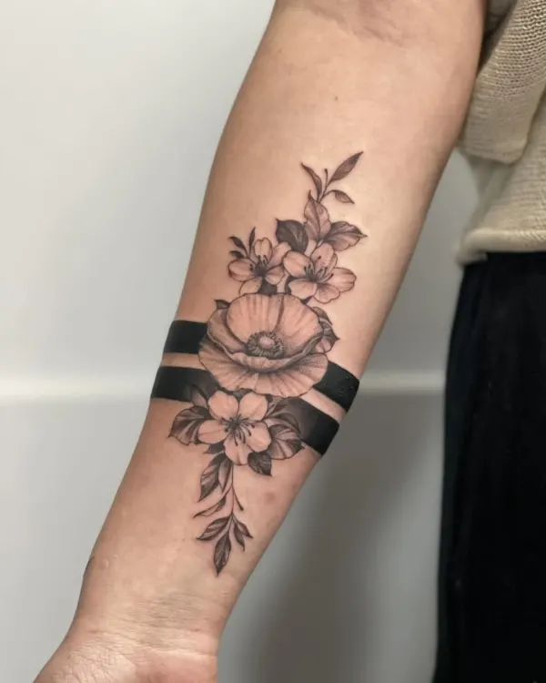 Tatuaj cu flori și benzi negre pe antebraț