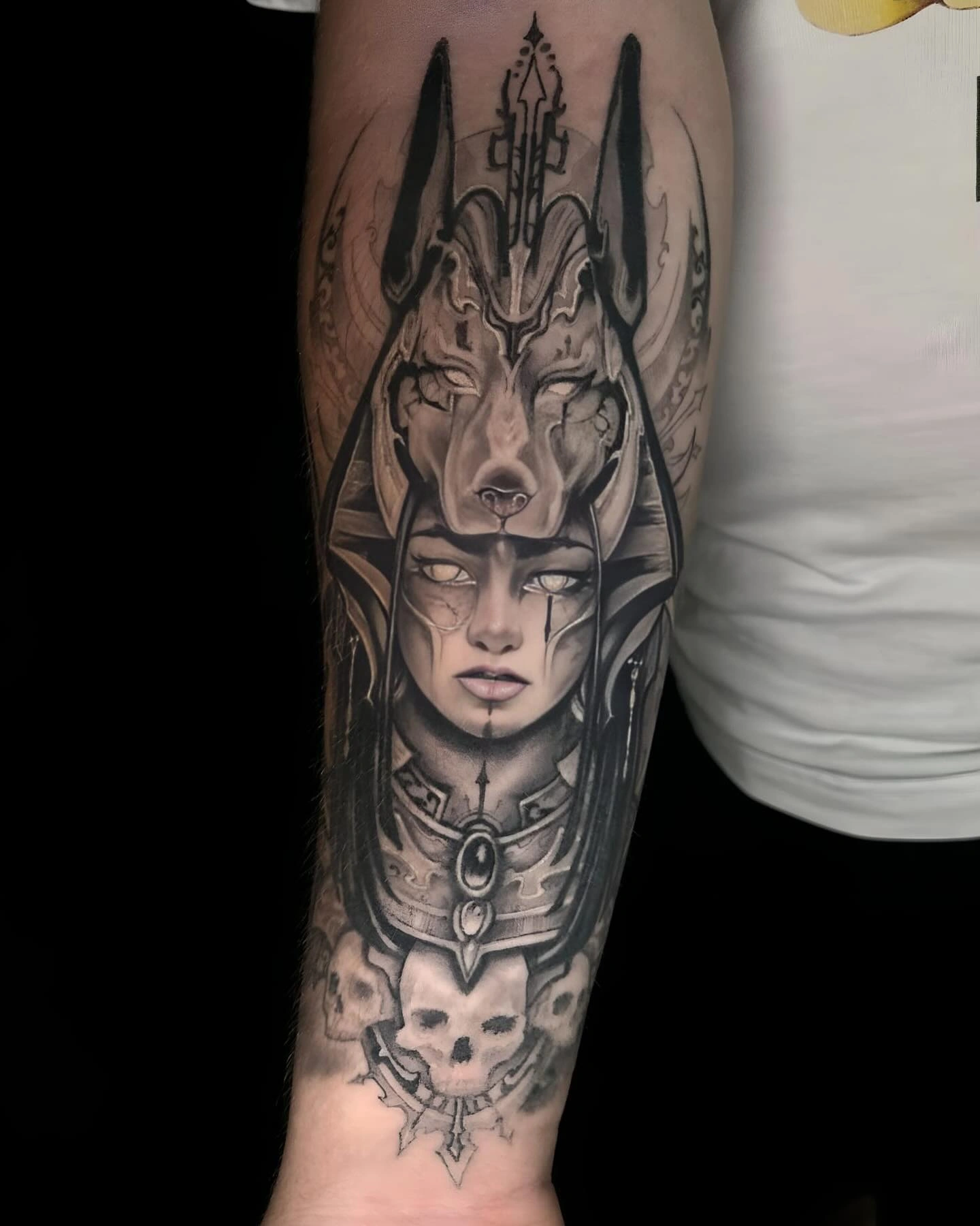 Tatuaj pe antebraț cu un chip feminin și cap de lup deasupra