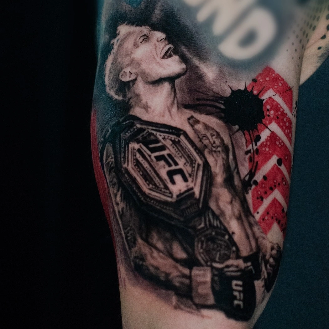 Tatuaj pe braț cu un luptător ținând o centură UFC