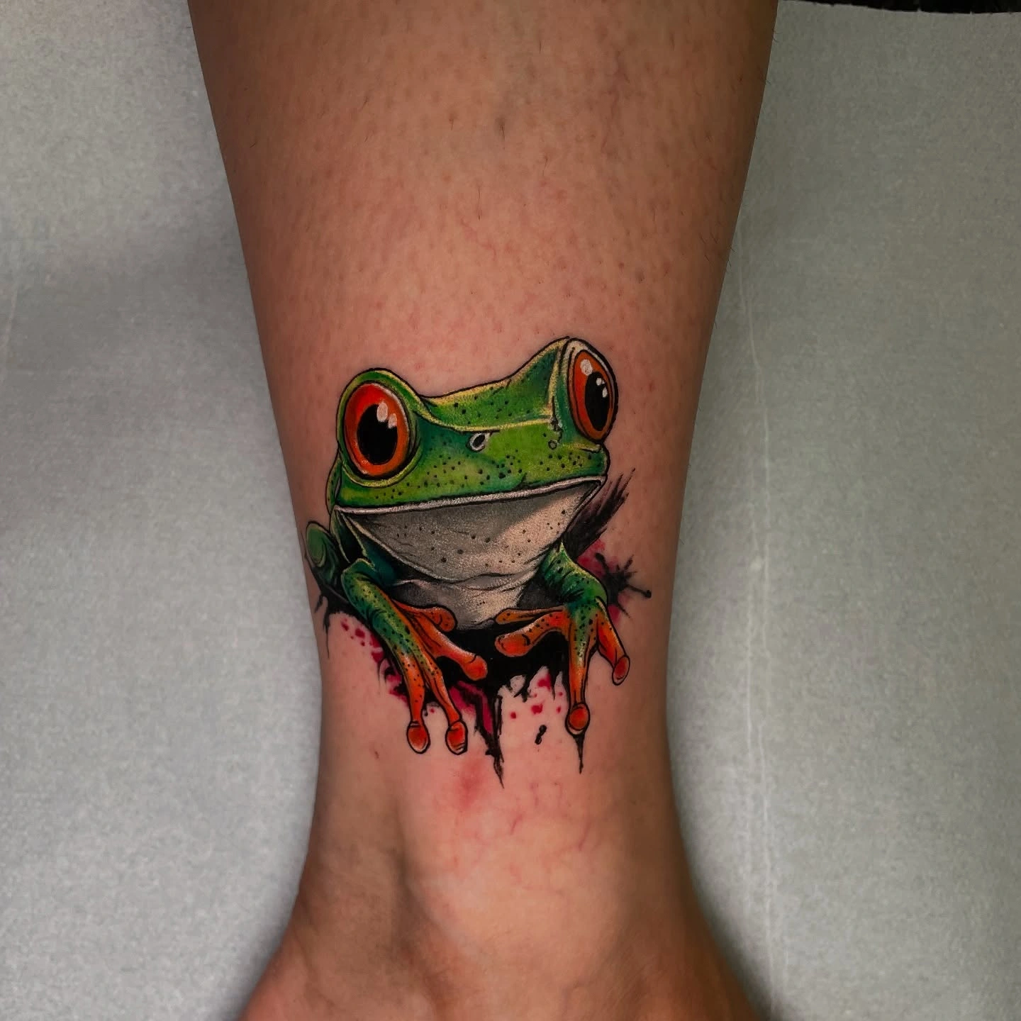 Tatuaj colorat cu o broască verde pe picior