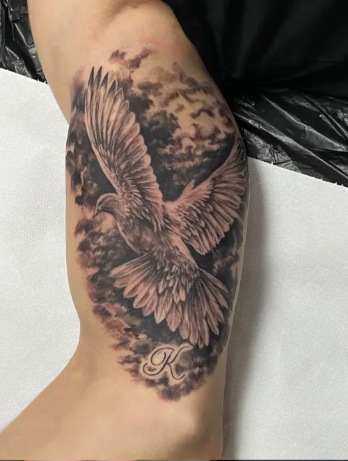 Tatuaj detaliat cu o pasăre în zbor pe braț