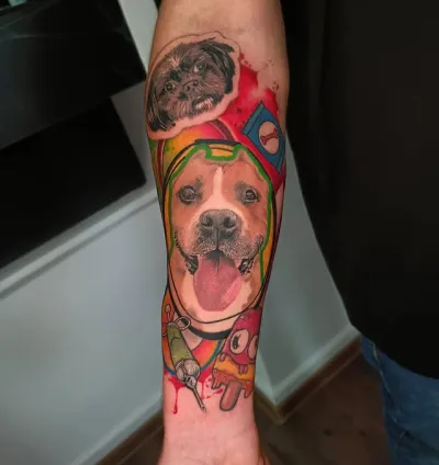 Tatuaj pe braț cu portrete colorate ale unor câini și elemente grafice vibrante